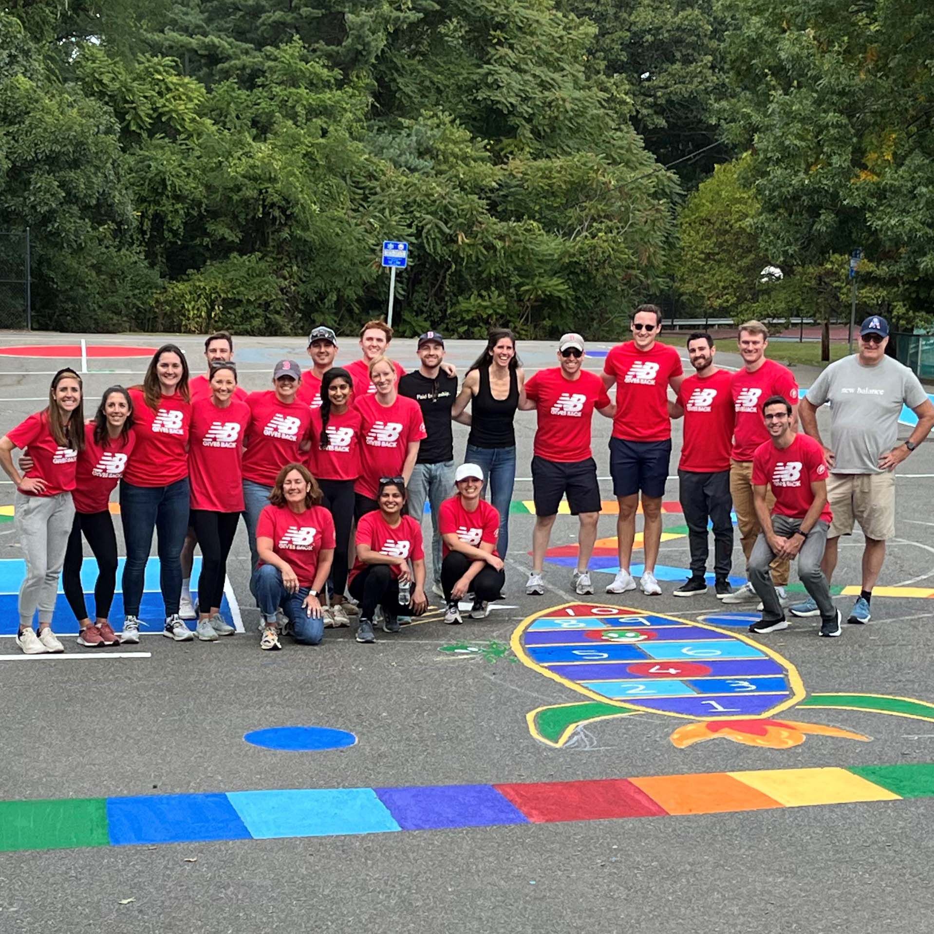 Group of NB volunteers standing outside on a basketball court