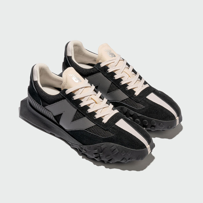 Isometric view of black XC-72 shoes in grey studio environment