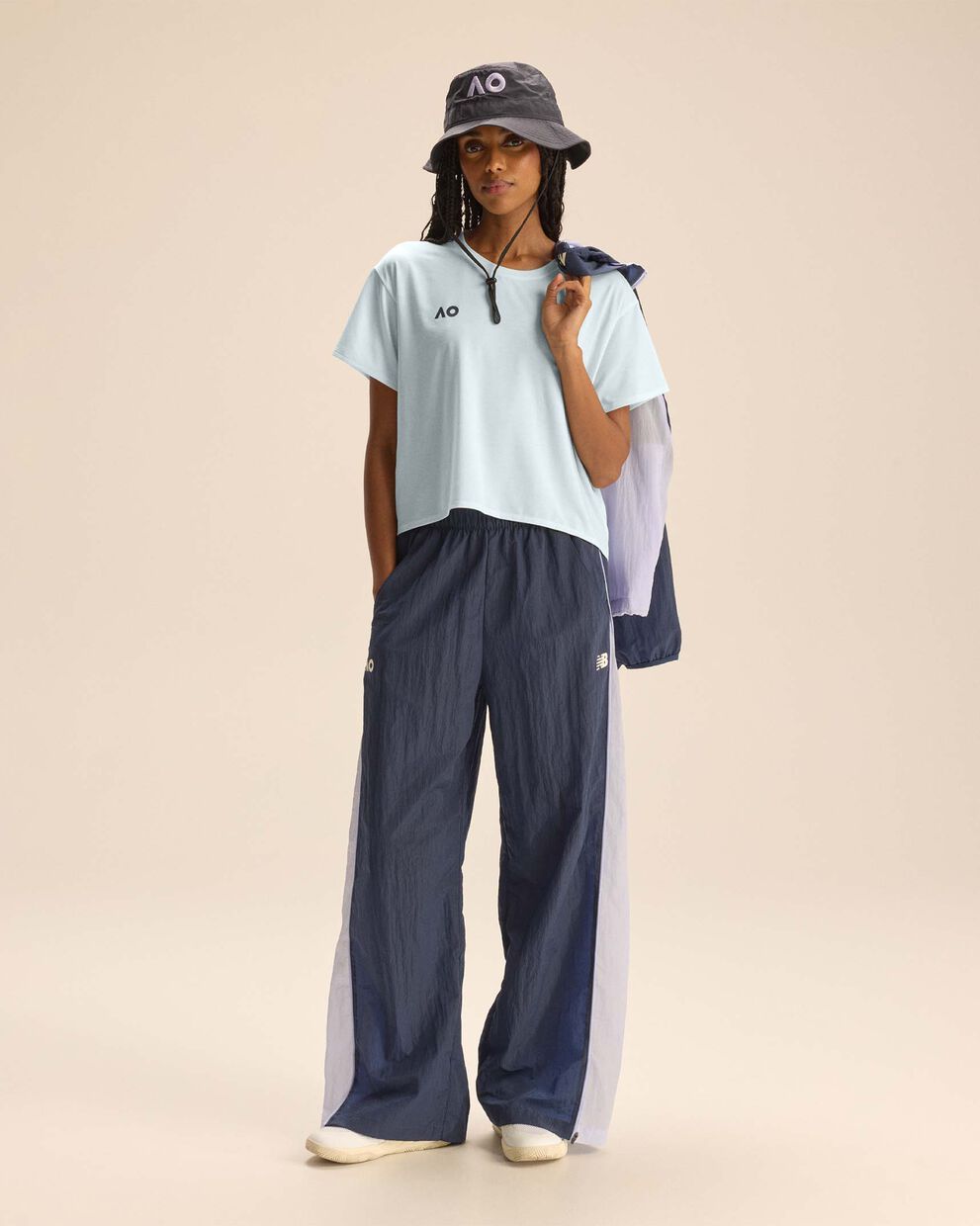 A person standing against a tan studio backdrop.