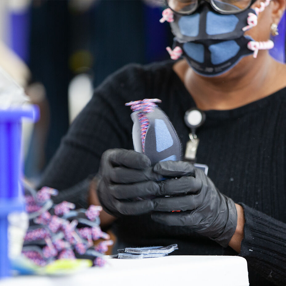 Factory worker assembling face mask