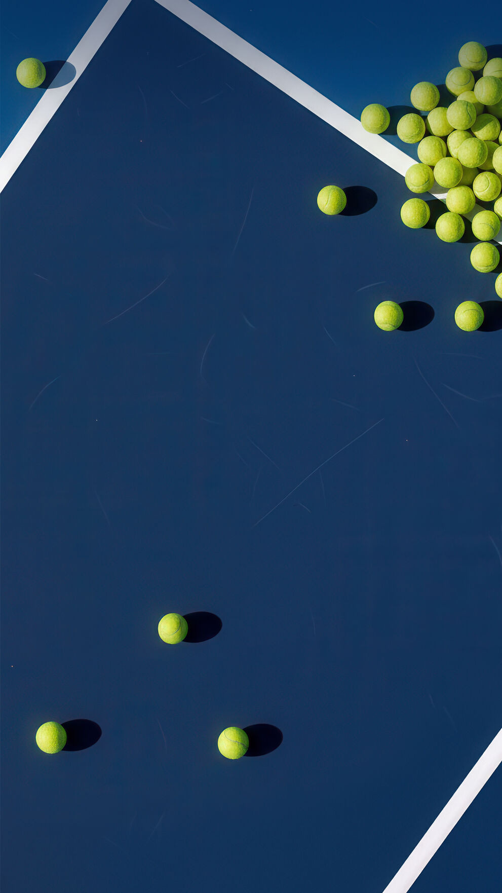 Tennis balls laying on a tennis court.