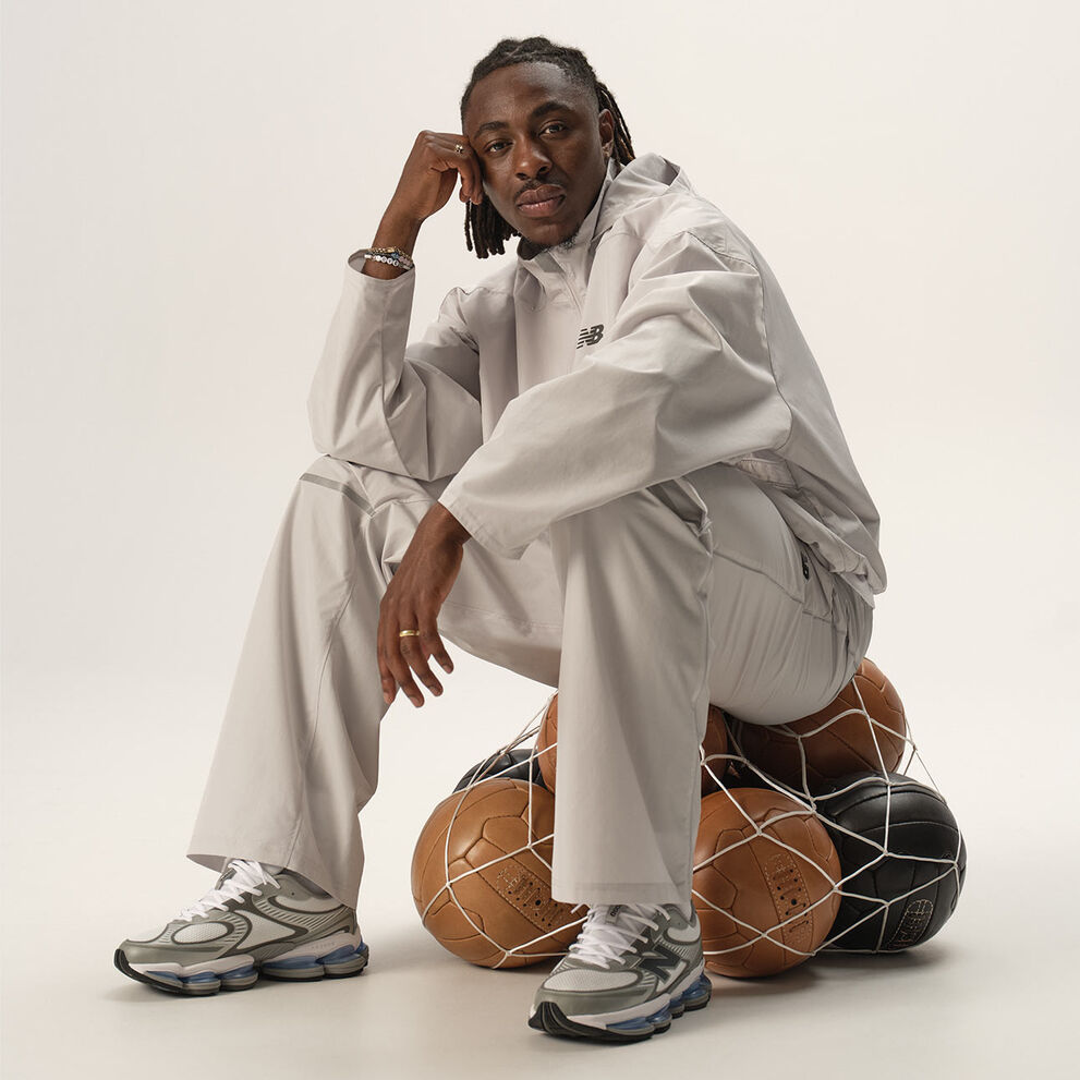 Football player Eberechi Eze sitting on footballs in studio. 