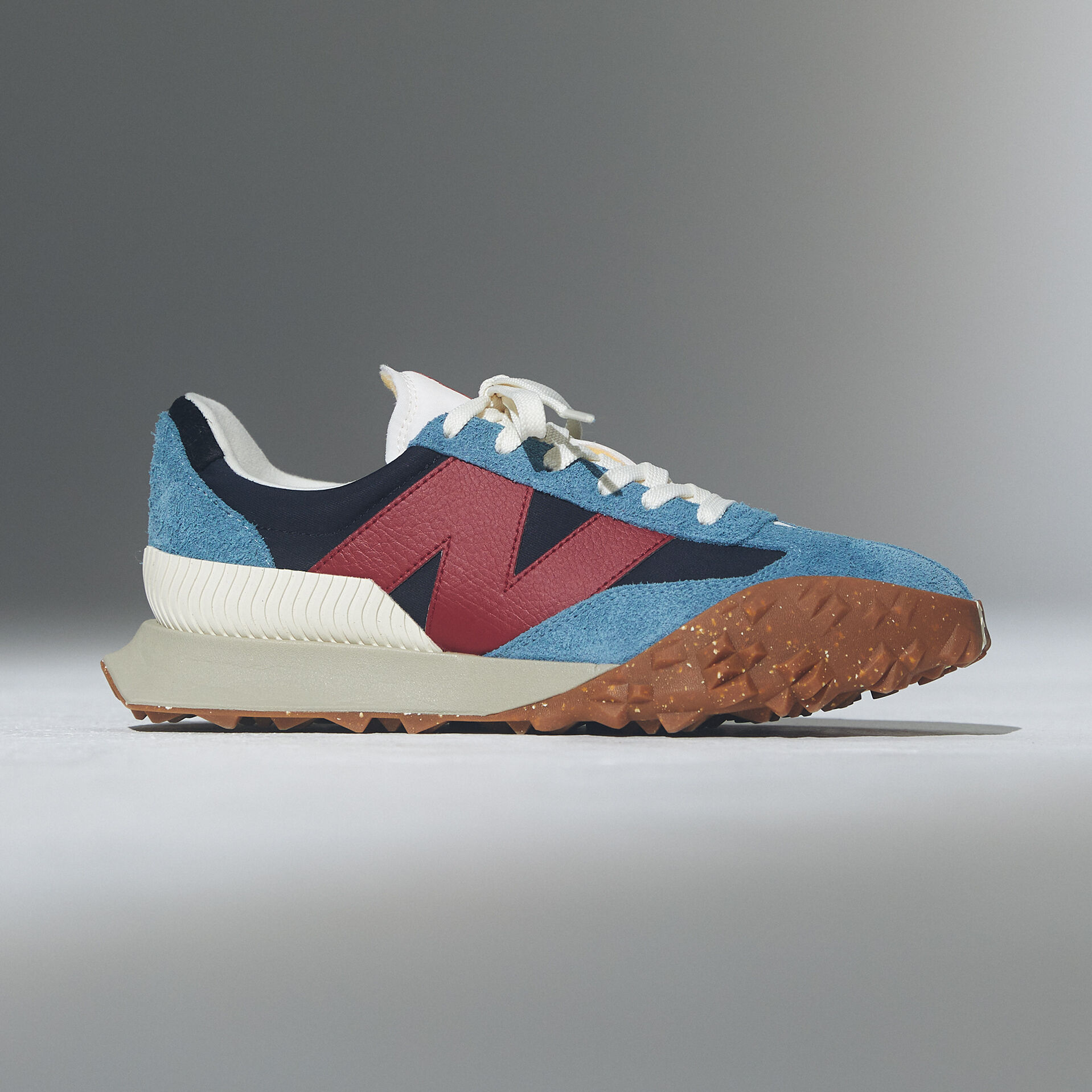 Single blue and red shoe on a grey background.